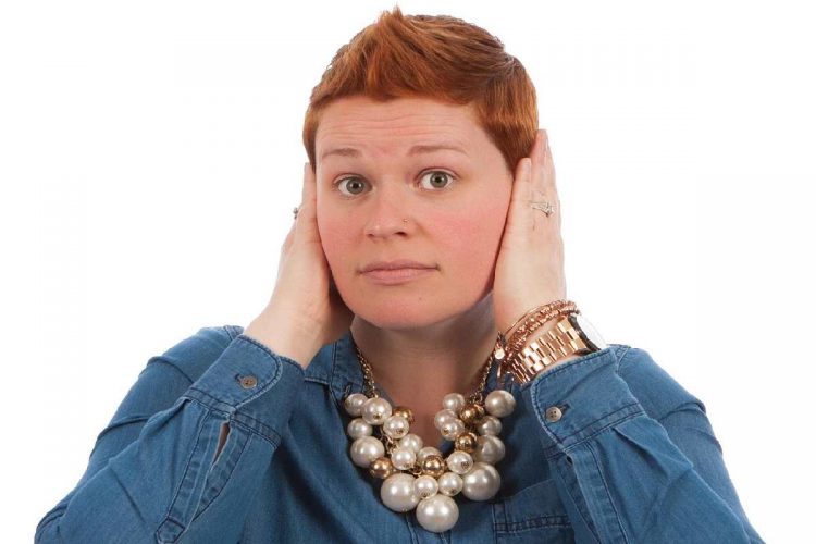 Una donna con le mani premute sulle orecchie