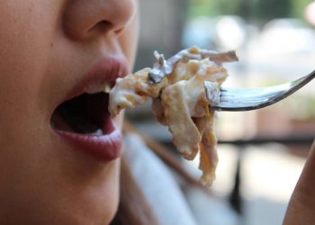 Una donna intenta a mangiare - Iss