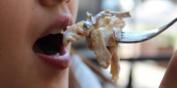 Una donna intenta a mangiare - Iss