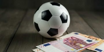 Un pallone da calcio vicino a delle banconote