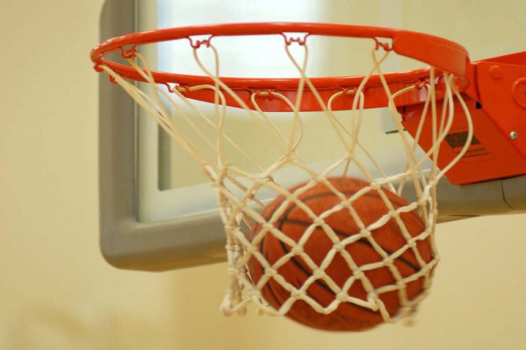 Una palla da basket che entra nel canestro