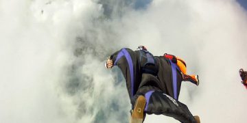 Una persona si getta nel vuoto indossando una tuta alare