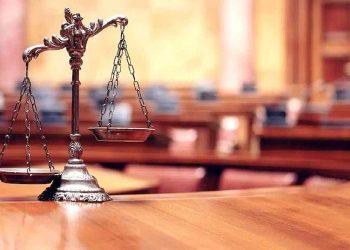 Una bilancia appoggiata su un banco all'interno dell'aula di un tribunale