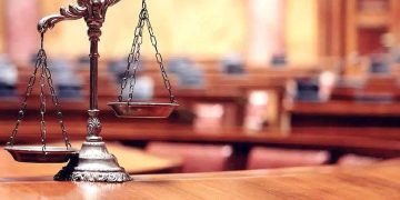 Una bilancia appoggiata su un banco all'interno dell'aula di un tribunale