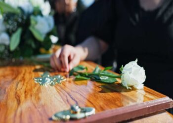 Un fiore appoggiato su una bara durante un funerale