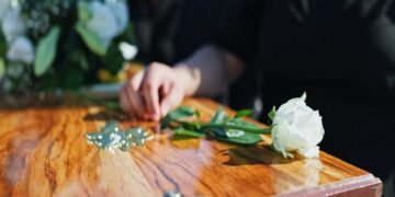 Un fiore appoggiato su una bara durante un funerale