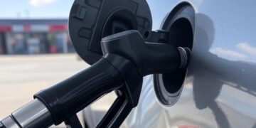 Una pompa di diesel inserita nello sportellino del bocchettone di rifornimento carburante di un auto