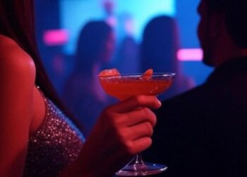 Una donna regge un drink in discoteca
