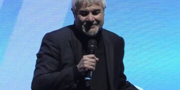 Il conduttore televisivo Pino Insegno parla con il microfono in mano