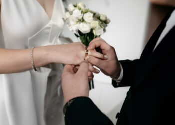 Una coppia di sposi che si scambiano gli anelli nel giorno del matrimonio