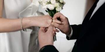 Una coppia di sposi che si scambiano gli anelli nel giorno del matrimonio