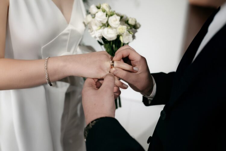 Una coppia di sposi che si scambiano gli anelli nel giorno del matrimonio