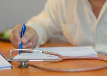 Un medico intento a compilare un referto