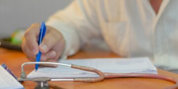 Un medico intento a compilare un referto