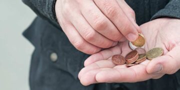 Una persona con delle monete in mano