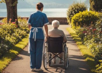 Una badante assiste un'anziana in carrozzina