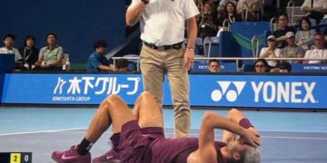 Carlos Alcaraz sdraiato a terra con le mani sul volto dopo un infortunio alla caviglia