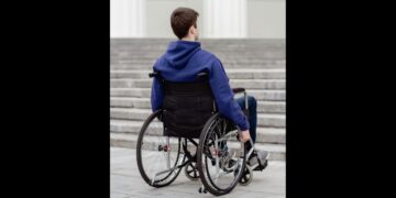 Ragazzo in sedia a rotelle davanti a rampa di scale