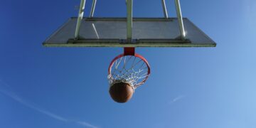 Una palla da basket dentro a un canestro