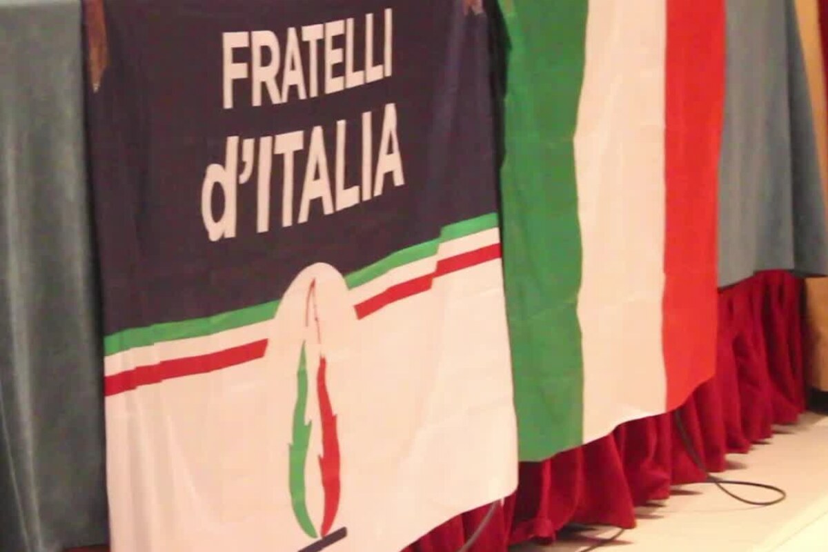 Una bandiera di Fratelli d'Italia di fianco a una italiana