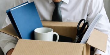 Una persona licenziata che raccoglie le sue cose in uno scatolone