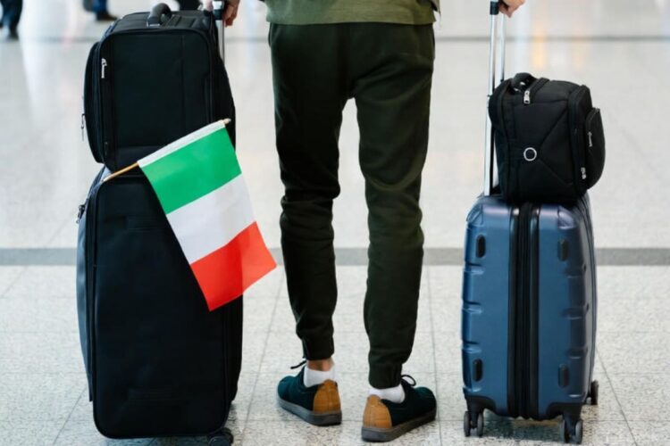 Un italiano con la valigia pronto a partire per l'estero