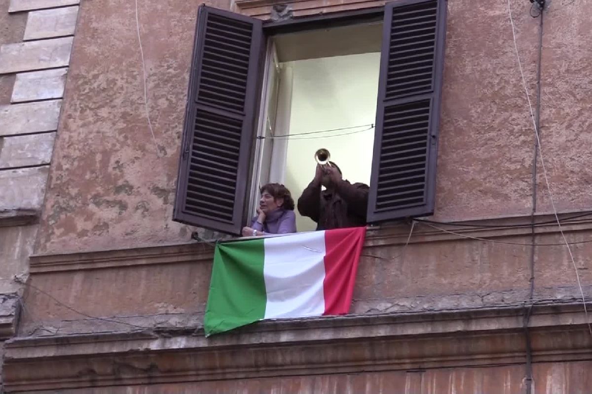 Due persone suonano l'inno di Mameli dal balcone di casa propria