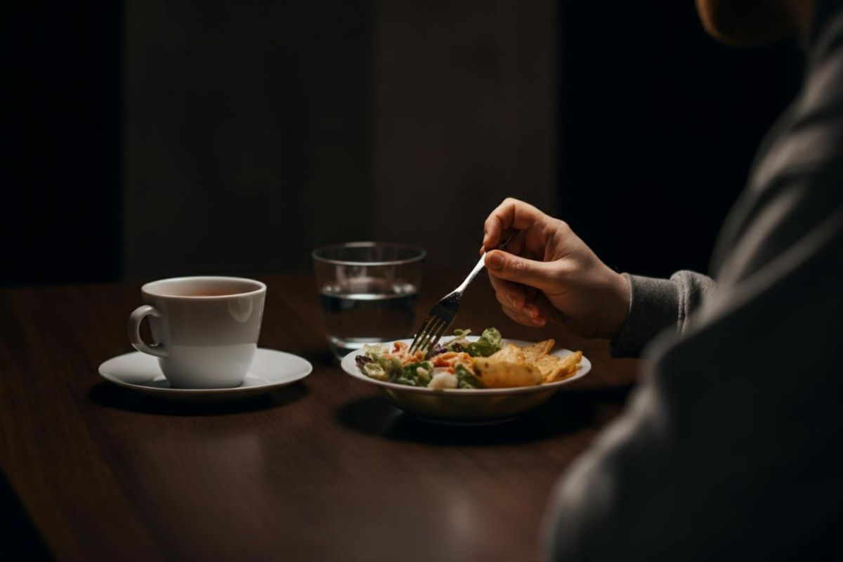 Persona influenzata che mangia a tavola