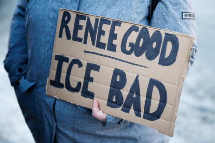 Un manifestante che regge un cartello contro l'ICE