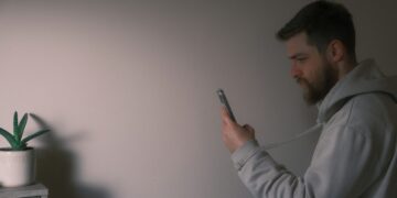 Un uomo con in mano uno smartphone