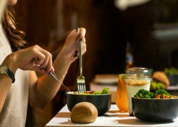 Una donna intenta a mangiare delle verdure