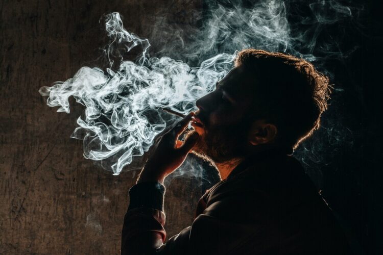 uomo fuma sigaretta