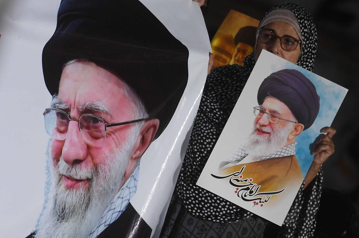 People hold portraits of Iranian Supreme Leader Ayatollah Ali Khamenei