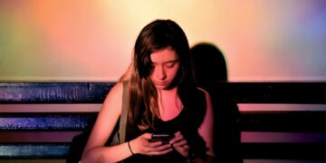 Un'adolescente con uno smartphone in mano