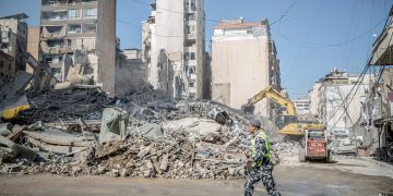 March 19, 2026, Beirut, Lebanon A policeman walks past the remains of a building in Bachoura, which was hit by an Israeli airstrike