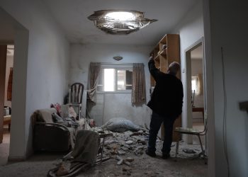 The owner of the house points at the damage in his living room caused by debris from intercepted Iranian ballistic missile in Petah Tikva, Israel, 15 March 2026