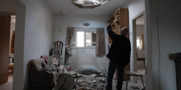 The owner of the house points at the damage in his living room caused by debris from intercepted Iranian ballistic missile in Petah Tikva, Israel, 15 March 2026