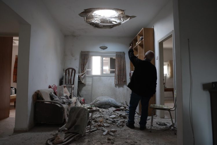 The owner of the house points at the damage in his living room caused by debris from intercepted Iranian ballistic missile in Petah Tikva, Israel, 15 March 2026