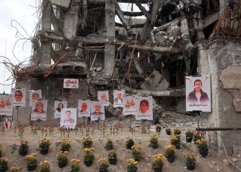 Photographs of airstrike victims displayed outside damaged building in Tehran