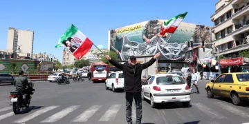 An Iranian man waves Irans national flags at the Enghelab square in Tehran, Iran, 22 April 2026