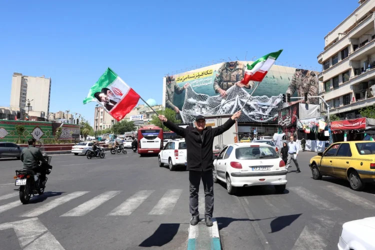 An Iranian man waves Irans national flags at the Enghelab square in Tehran, Iran, 22 April 2026