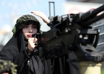 An Iranian woman rides a military vehicle in Tehran