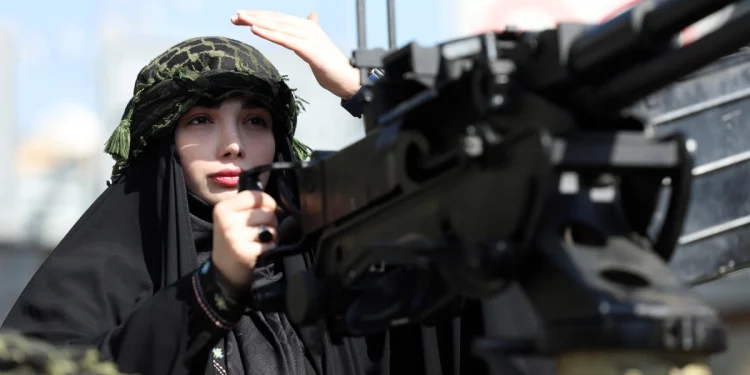 An Iranian woman rides a military vehicle in Tehran