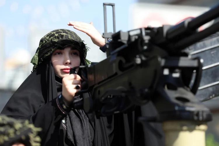 An Iranian woman rides a military vehicle in Tehran