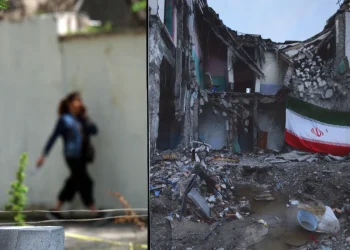 An Iranian woman walks next to an image depicting war damage in a park in Tehran, Iran, 21 April 2026