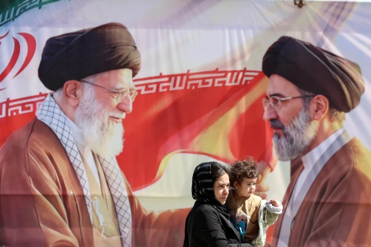 Iranians pass a billboard depicting late Iranian supreme leaders in Tehran, Iran, 23 April 2026