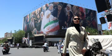 a-woman-walks-next-to-a-huge-billboard-in-a-street-in-tehran-iran-25-may-2026-1200x800.webp