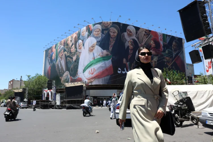 a-woman-walks-next-to-a-huge-billboard-in-a-street-in-tehran-iran-25-may-2026-1200x800.webp