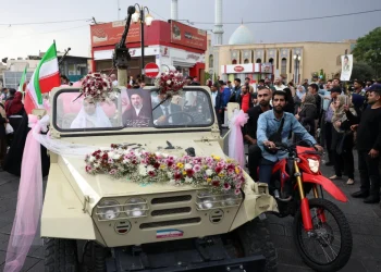 an-iranian-bride-and-groom-arrive-on-a-military-vehicle-during-a-mass-wedding-ce-1200x800.webp