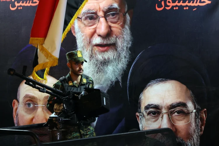 an-iranian-military-member-stands-guard-in-front-of-the-picture-of-late-iranian--1200x800.webp